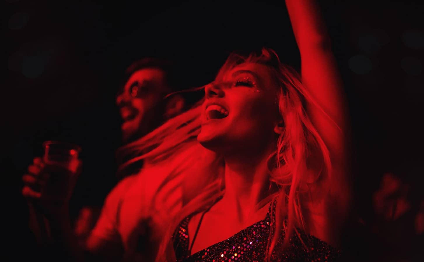 Chica bailando bajo luces rojas en una fiesta de fin de año